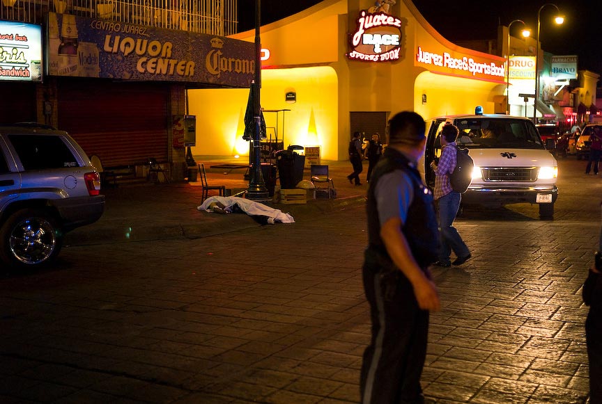 Juárez: dead body with police and onlookers, nighttime; © Julián Cardona