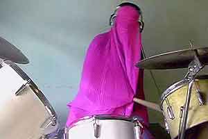 Girl at drums covered in pink burqa