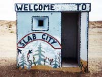Hut painted with words: Welcome to Slab City