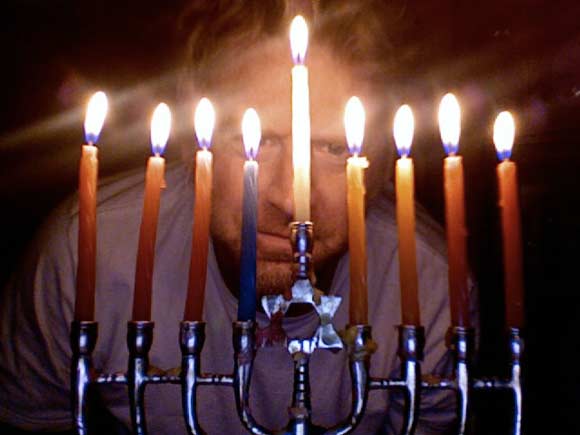 BG behind menorah with lit candles