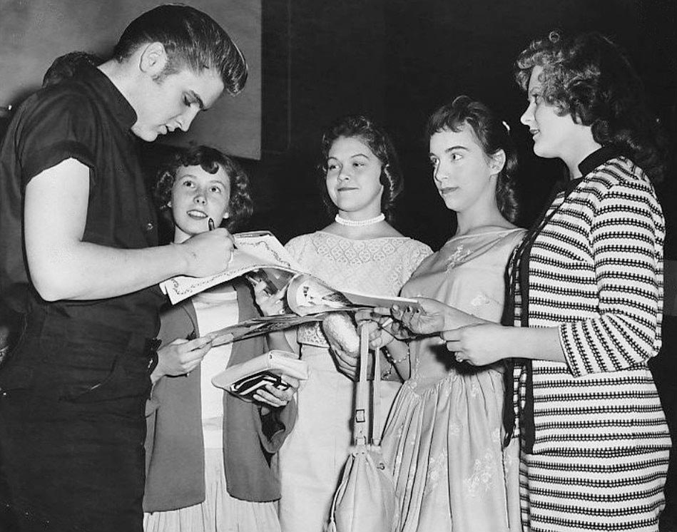 Elvis Presley signing autographs for young women fans, Minneapolis, Minnesota, June 1956