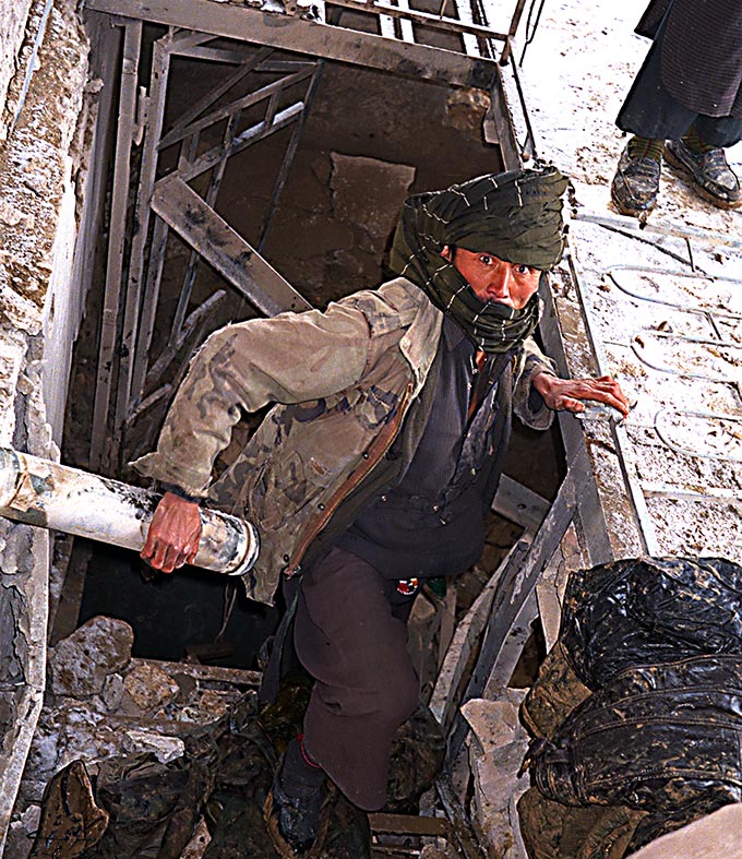 Worker bringing coats up from the Qala-i-Jhangi basement