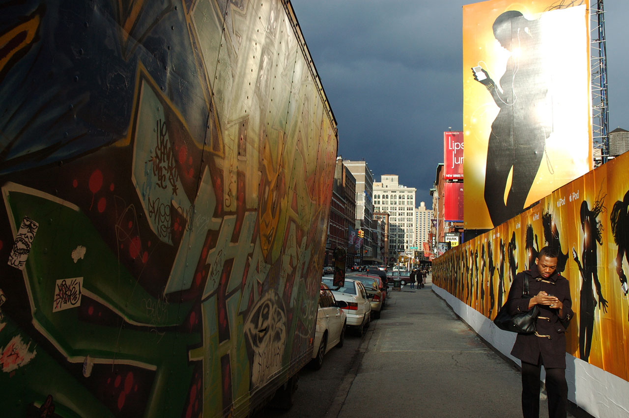 Billboard ad for iPod, with man walking underneath listening to an iPod