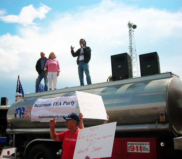 Speaker on top of fire truck with Bozeman Tea Party signs