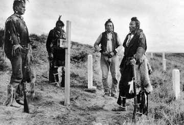 Men standing by crosses marking graves